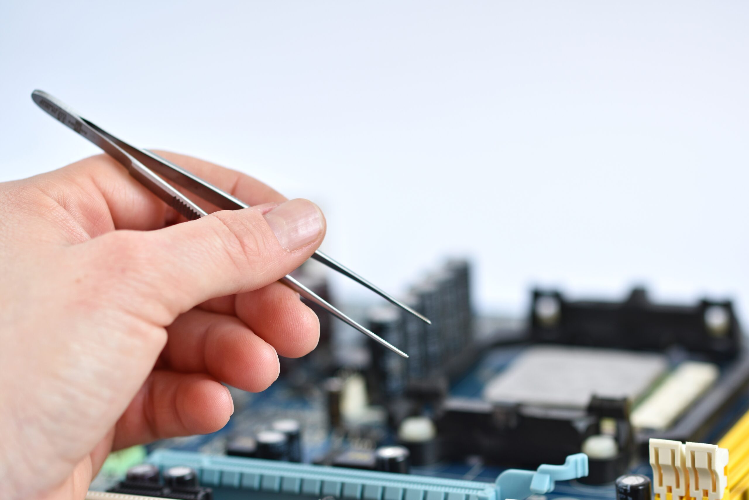 close-up-hand-with-pliers-check-motherboard